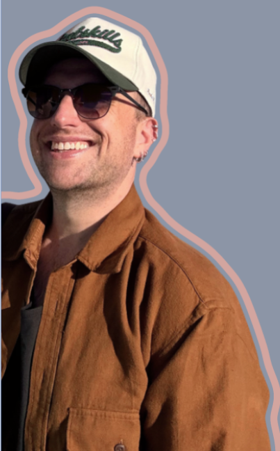 Clay outdoors in a Catskills cap, sunglasses and a brown jacket, smiling