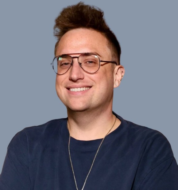 Clay Klaus-Wade, smiling, in glasses and a navy t-shirt